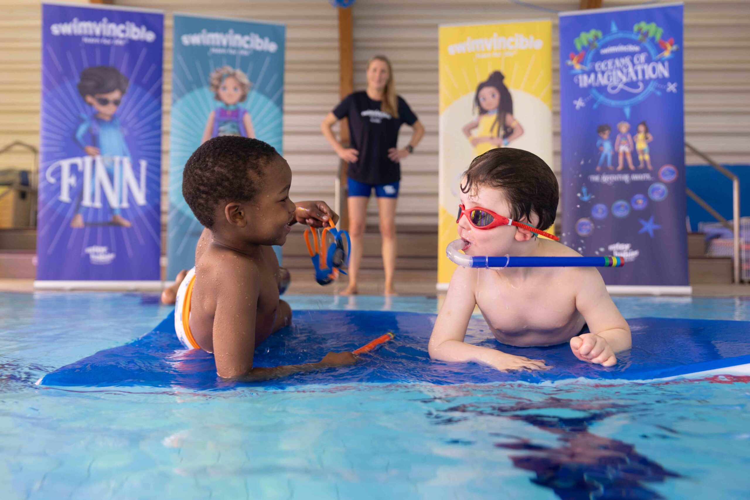 two swimvinvcible students on a mat