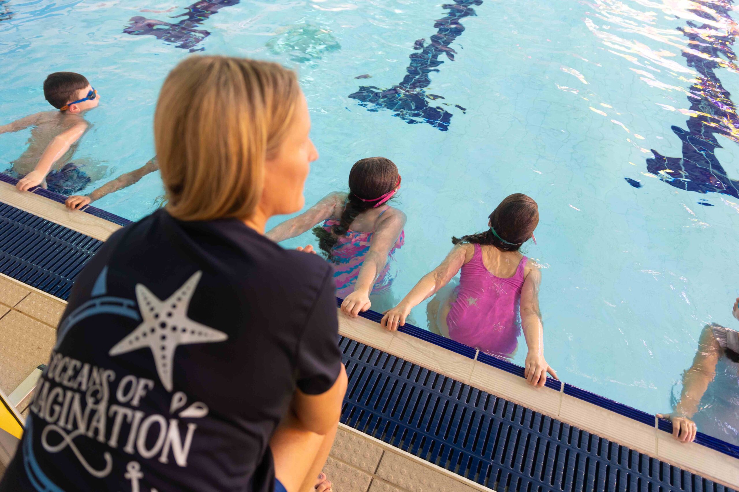 swimvincible teacher with students in the pool